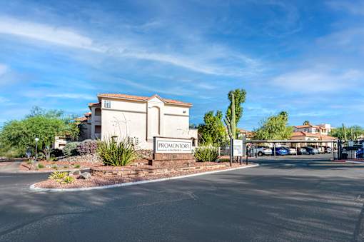 The Promontory sign is on a building with a parking lot in front.