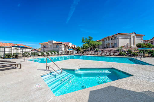A large swimming pool with a ladder and a building in the background.