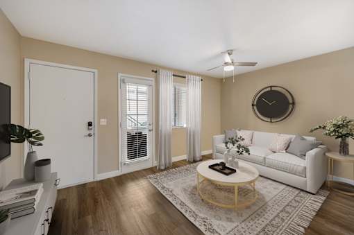A living room with a white couch, a coffee table, and a ceiling fan.