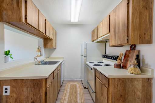 A kitchen with wooden cabinets and a white refrigerator.