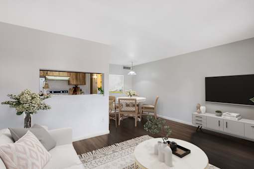 A living room with a white couch, a coffee table, and a flat screen TV.