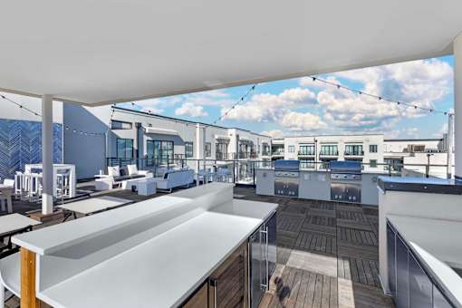 A rooftop patio with a white table and chairs.