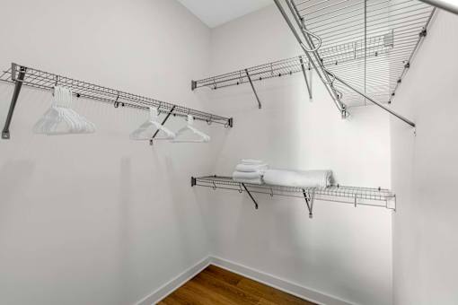 A white laundry room with a clothes drying rack and towel rack.