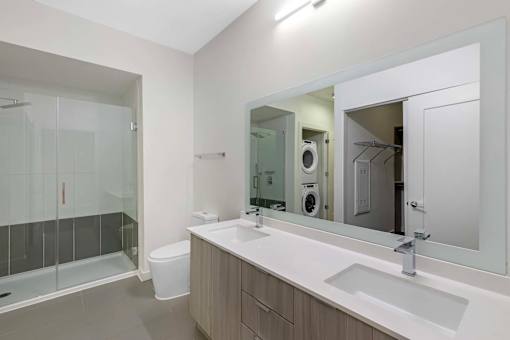 A modern bathroom with a glass shower door and a white sink.