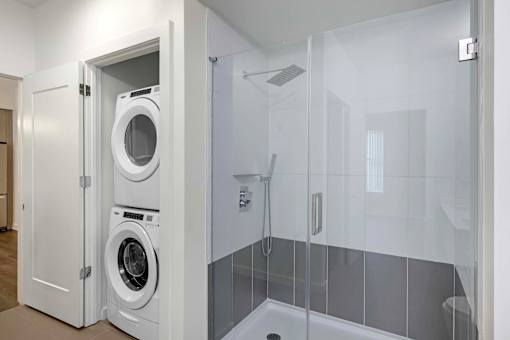 A white laundry room with a washer and dryer in a cabinet.