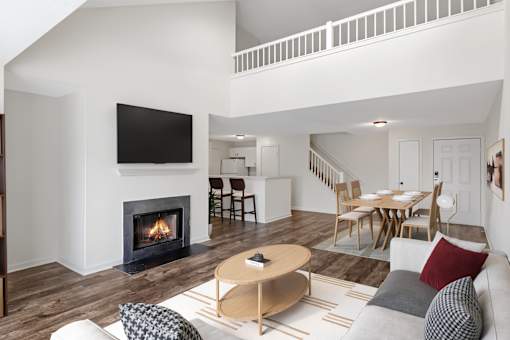 A modern living room with a fireplace and a television at Residences at Westborough Station, Westborough, MA