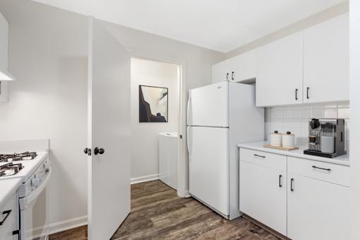 A kitchen with white appliances and cabinets at Residences at Westborough Station, Westborough, MA