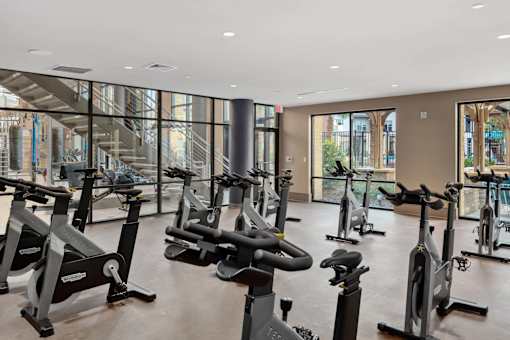 A gym with a row of stationary bikes.