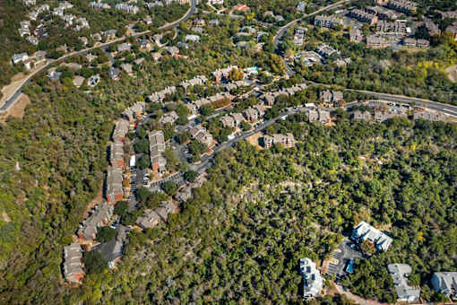 Top view of residential area surrounded by trees at Great Hills, Texas