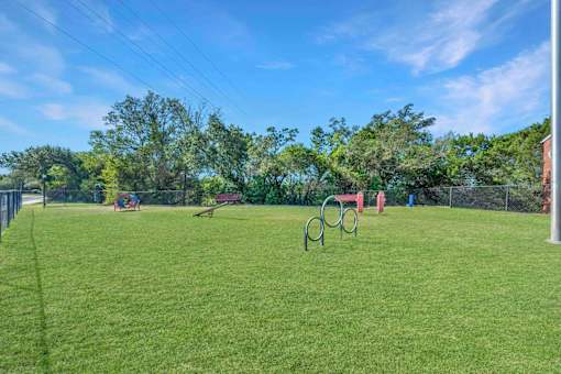 Grassy field with a playground at Great Hills, Austin, 78759