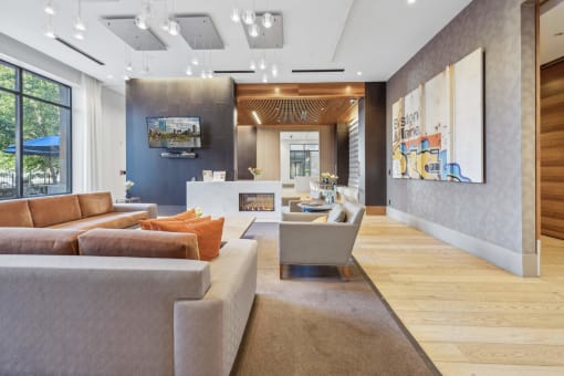 a living room with couches and chairs and a fireplace at The Merc, Waltham, MA, 02453