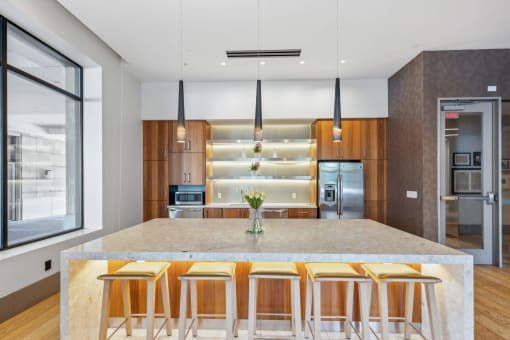 a kitchen with a marble counter top and bar stools at The Merc, Waltham, Massachusetts