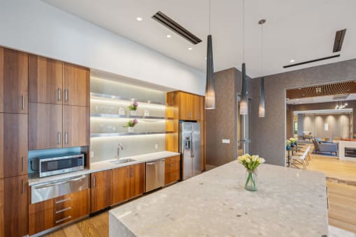 a large kitchen with wooden cabinets and a marble counter top at The Merc, Waltham