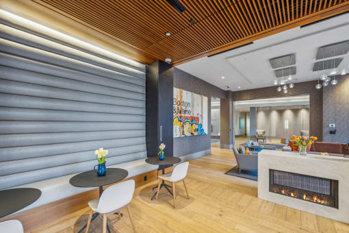a lobby with tables and chairs and a fireplace at The Merc, Massachusetts, 02453