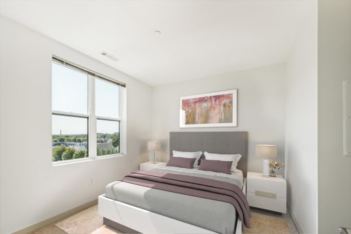 a bedroom with a bed and two windows at The Merc, Waltham