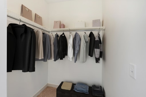a closet with a rack of clothes and boxes on the wall at The Merc, Massachusetts, 02453