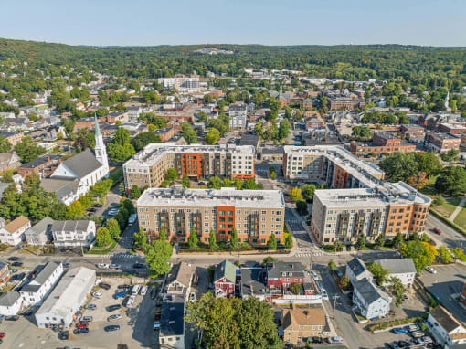 an aerial view of a city with buildings and trees at The Merc, Massachusetts, 02453