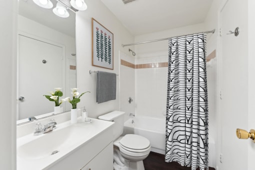 a white bathroom with a black and white shower curtain at Residences at Westborough Station, Westborough