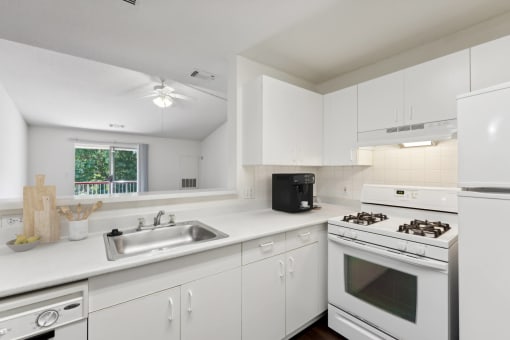 a kitchen with white cabinets and appliances and a sink at Residences at Westborough Station, Westborough, 01581