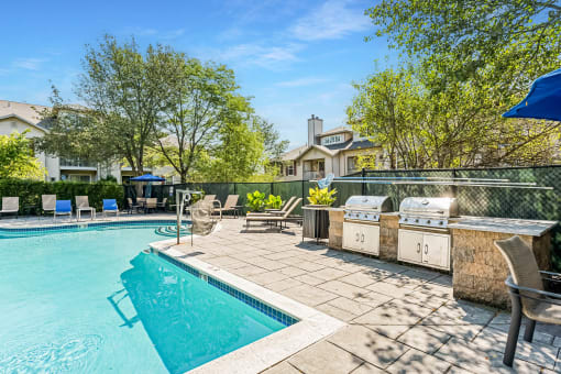 a swimming pool with a grill next to a resort style pool at Residences at Westborough Station, Massachusetts, 01581