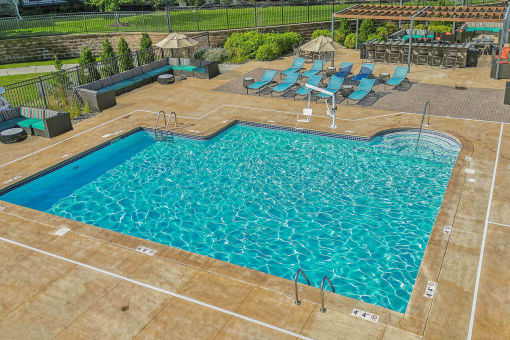 a large swimming pool with lounge chairs around it at SoRoc on Maine in Rochester, MN