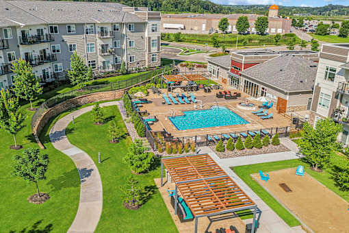 A large outdoor pool area with a wooden deck and a hot tub.