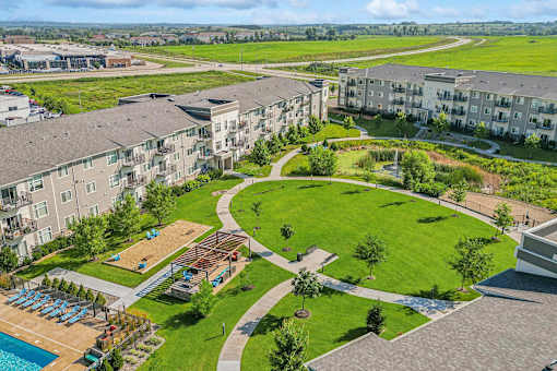 A large apartment complex with a swimming pool and a landscaped area.