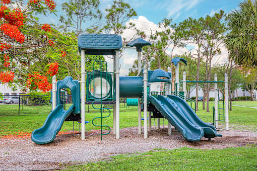 A playground with a green slide and a blue and green play structure.