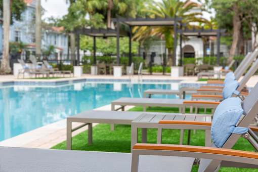 A poolside lounge area l at Floresta apartments in Jupiter, FL
