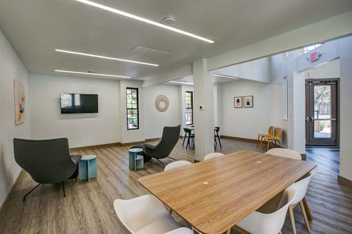 A conference room with a long table surrounded by chairs.