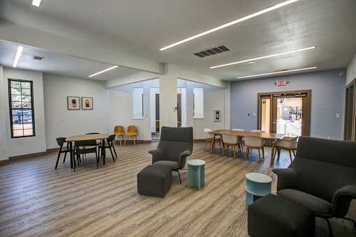 A room with wooden floors and furniture including a table and chairs.