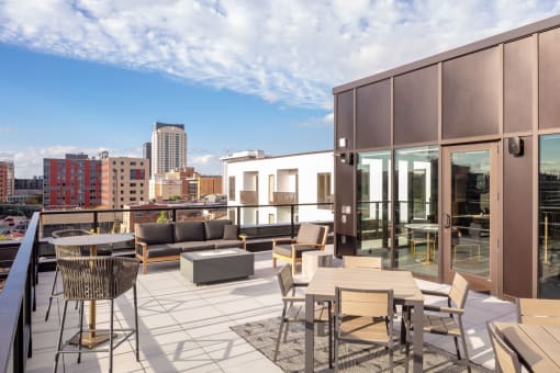 a balcony with tables and chairs and a view of the city at Maven on Broadway, Rochester, MN, 55904