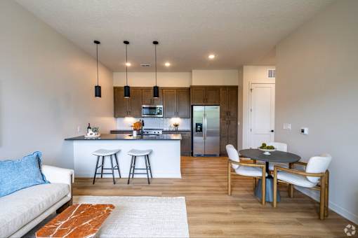 A kitchen with a bar area and a dining table with chairs.
