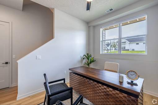 A room with a desk and chair in it.