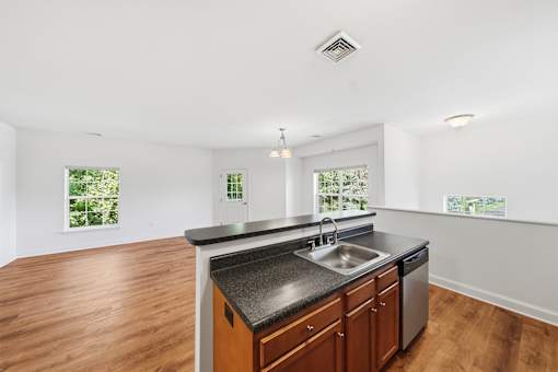 A kitchen with a black countertop and wooden cabinets.