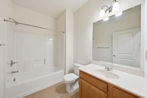 A white bathroom with a toilet, sink, and bathtub.