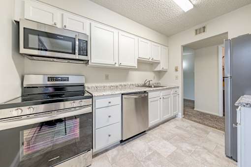 a kitchen with stainless steel appliances and white cabinets