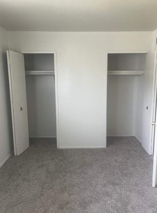 The bedroom in a 1 bedroom unit with 2 closets