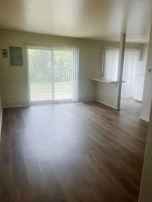 The living room in a 1 bedroom apartment with a sliding glass door.