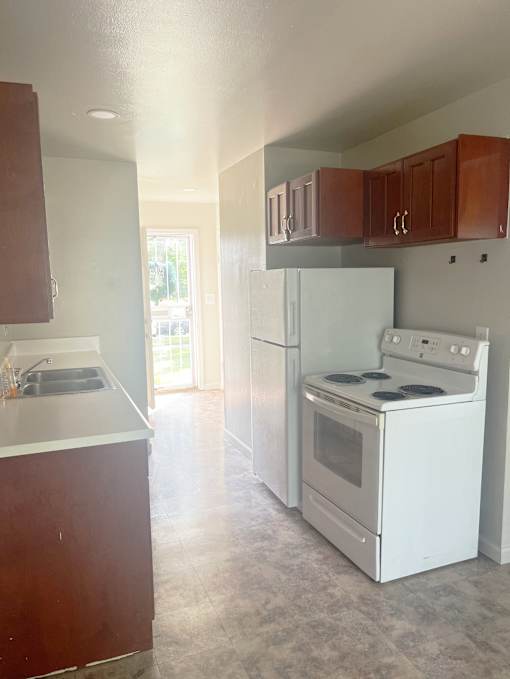 A kitchen with white appliances and wooden cabinets