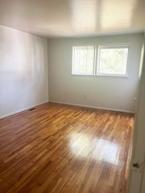 The Primary bedroom with a window and wooden floors