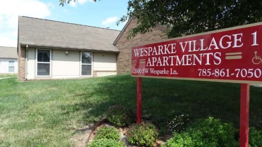 a sign in front of a house that says weaver village apartments