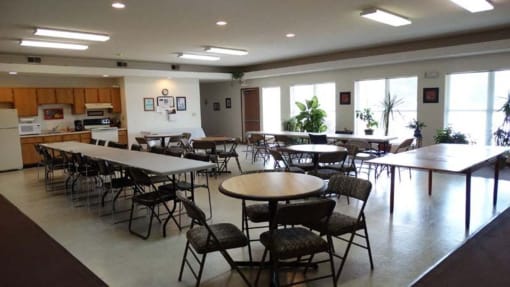 a dining room with tables and chairs and a kitchen