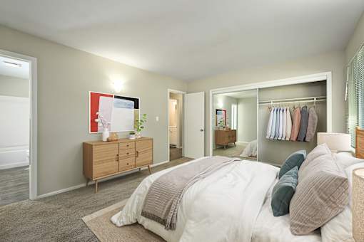 A bedroom with a large bed and a wooden dresser.