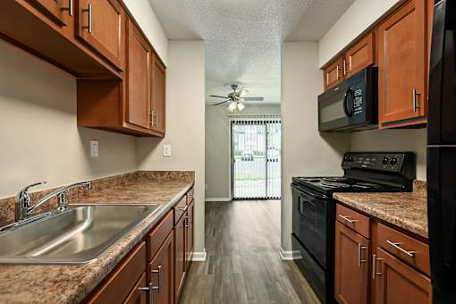 A kitchen with wooden cabinets and a black stove top oven.