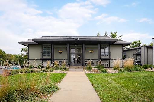 A modern house with a grey roof and a glass door.