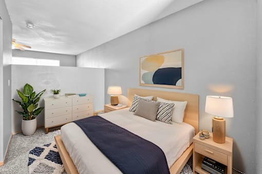 A bedroom with a large bed and a painting on the wall.