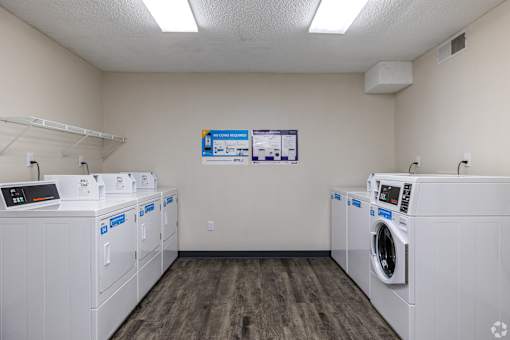 A laundromat with a row of washers and dryers.