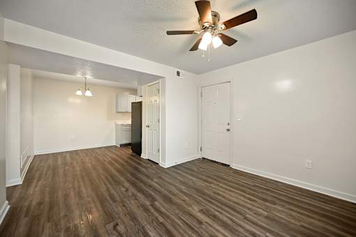 A room with a ceiling fan and wooden flooring.