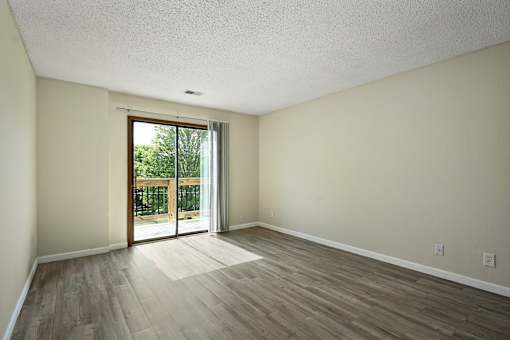 A room with a sliding glass door leading to a backyard.